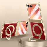Red smartphone with gold stand and ring on a beige background